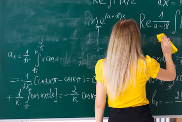 Young female student in front of the chalkboard