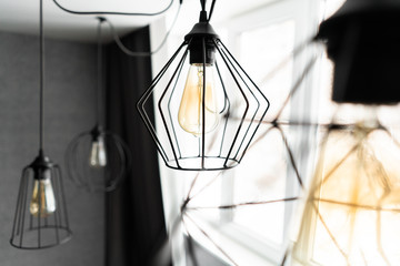 loft style iron lampshade with a light bulb in the interior living room in modern apartment. Vintage style light bulbs. glass round bulbs with a spiral on wall. - Powered by Adobe