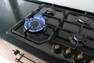 Closeup shot of blue fire from domestic kitchen hob. Gas cooker with burning flames propane gas.