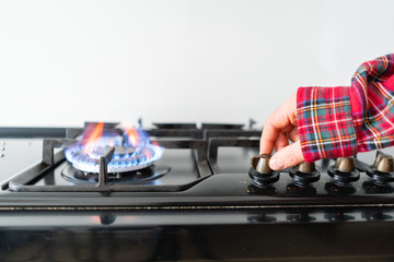 A man lighting the gas-stove with by means of automatic electric ignition. Modern gas burner and...