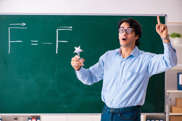 Young male physic standing in front of the green board