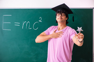 Young male physic standing in front of the green board