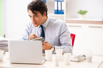 Fototapeta premium Young employee addicted to coffee