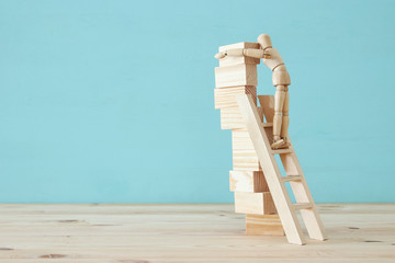 concept photo of obstacles overcoming, wooden dummy looking at a barrier and thinking about solution.