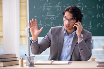 Young handsome math teacher in classroom 