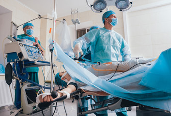 Process of gynecological surgery operation using laparoscopic equipment. Group of surgeons in...