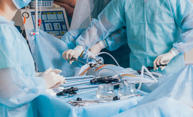 Process of gynecological surgery operation using laparoscopic equipment. Group of surgeons in operating room with surgery equipment