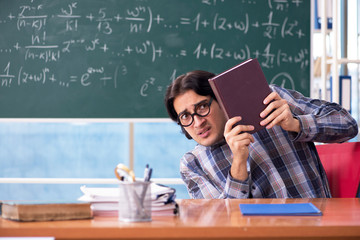 Young funny math teacher in front of chalkboard 