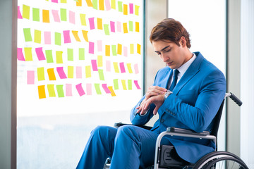 Young handsome man in wheelchair with many conflicting prioritie