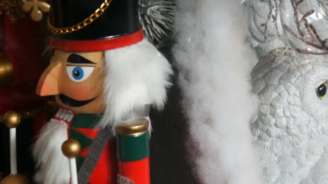 Wooden figures of fairy-tale nutcrackers and white owls spinning on the window of the Christmas market with a price tag and discount