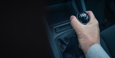 Man hand holding gear shift on his auto