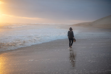 Woman walking on beach during sunset 