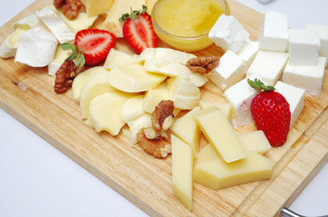 Cooking berry cheese salad. Strawberries, cheese, feta cheese, honey, nuts