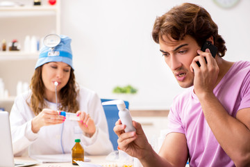 Young handsome man visiting young female doctor otolaryngologist