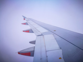 Fototapeta premium Left Aircraft wing flying isolated on white cloud sky.