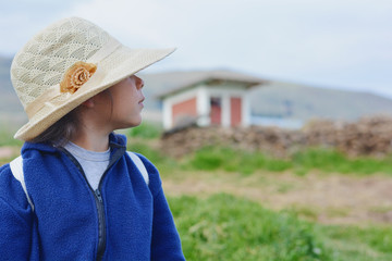 Little lady wearing hat in the countryside.