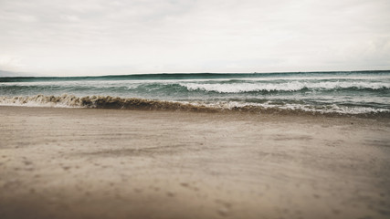 ocean waves on beach in cloudy day