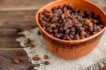 Raisins on wooden background.