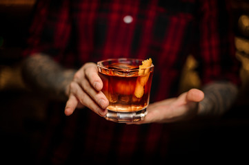 Bartender serving a glass of a Foreign Legion cocktail on the bar counter