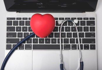 Health stethoscope and red heart on keyboard of laptop computer