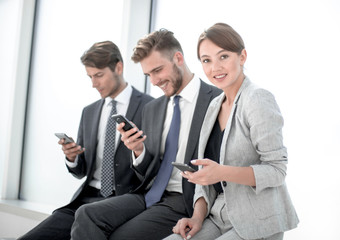 smiling employees using their smartphones.