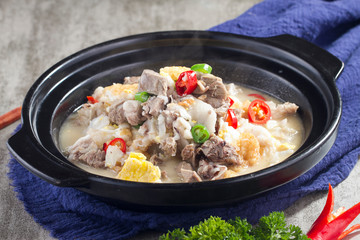 Braised pork bone with meat in a black pot