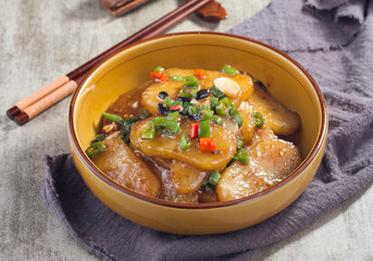 Braised potato chips with red and green pepper in a ceramic dish