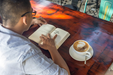 Young man reading book in the morning