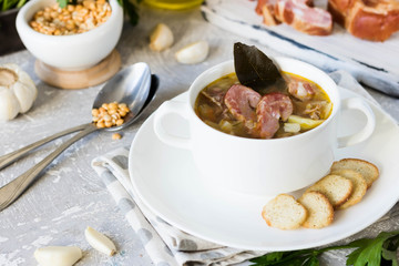 Thick pea soup with smoked meats in a white plate