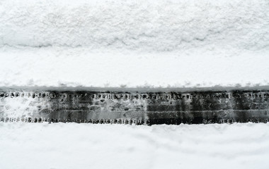 cleared path through deep snow on an asphalt road after a heavy snowfall