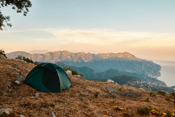 Tenda su paesaggio montano durante l'alba