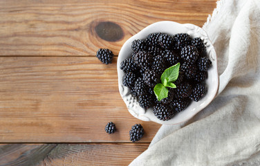Freah blackberries in bowl and leaves closeup