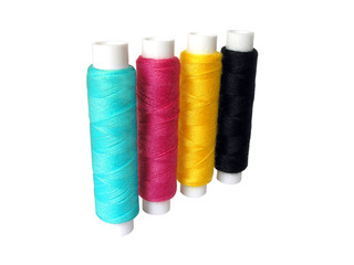 Four spools of thread colors CMYK on white background