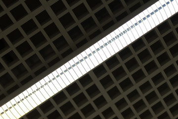 Lights and ventilation system in long line on ceiling of the dark office industrial building or exhibition Hall Ceiling construction