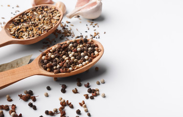 Mixed peppercorns and spices in wooden spoon