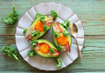 Breakfast. Avocado Egg Boats with crunchy bacon, kale cabbage. Top view