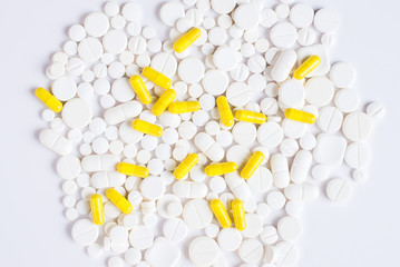 White and yellow pills on a white background