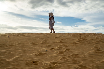 Woman in the Red Sand Dunes in Mui Ne with Footprints in the Sand