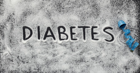 Diabetes word written on white scattered sugar
