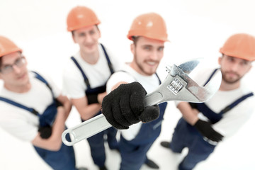 closeup.a team of builders showing a pipe wrench
