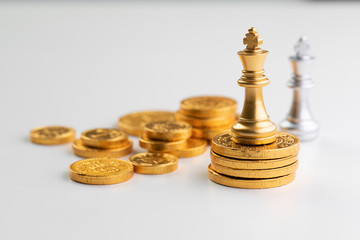 Golden chess king standing on gold coins, stand out from the crowd concepts