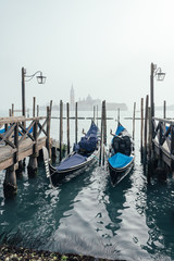 Fototapeta na wymiar Morning in Venice. Fog in venetian lagoon. Gondolas floating in the water
