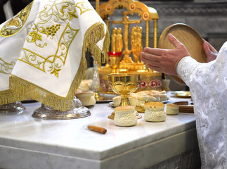 Orthodox priest during the liturgy, holds the sacrament