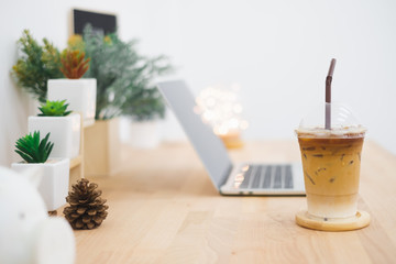 Ice coffee on table desktop in cafe for freelance workplace concept