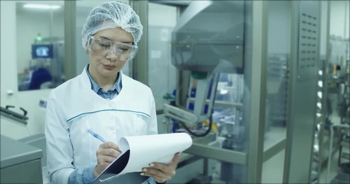 Pharmaceutical Factory Worker. Worker Using Control Panel.A female technician is monitoring the process.