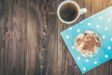 Cottage cheese with cinnamon and tea on wooden background.