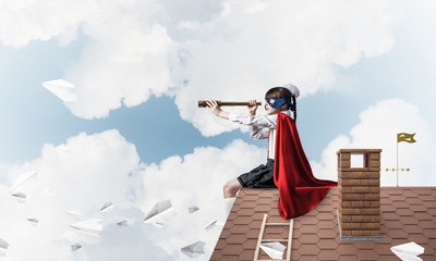 Girl power concept with cute kid guardian against cloudscape bac