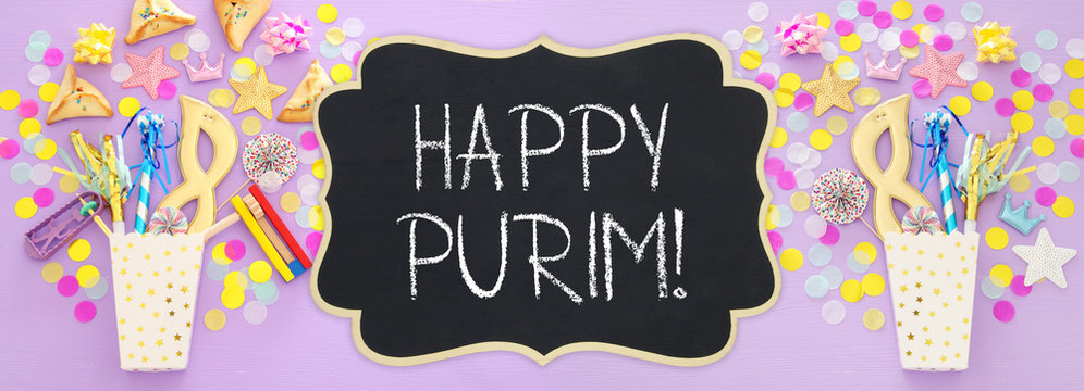 Purim celebration concept (jewish carnival holiday) over wooden pink background. Banner.