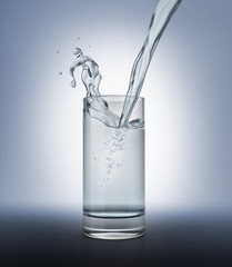 Glass full of clear water with pouring and splash.
