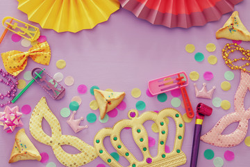 Purim celebration concept (jewish carnival holiday) over wooden pink background